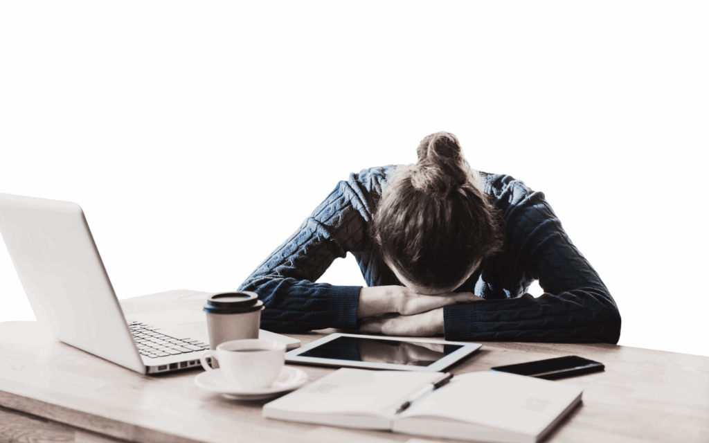 Exhausted employee with head down on desk surrounded by laptop, coffee cups, tablet, and smartphone, illustrating workplace burnout and change fatigue